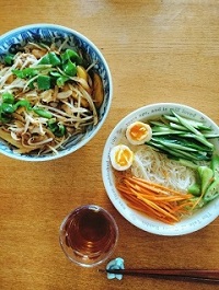 2つの丼に麺が入れられその上にたくさんの野菜が盛られている写真