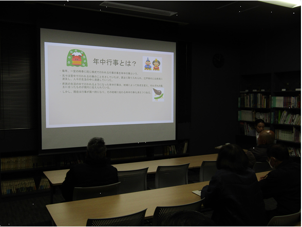 図書講座室でスクリーンに年中行事を説明する画像が映し出され、参加者がそれを見ている
