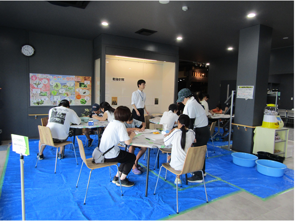 博物館のエントランスでまが玉を作る参加者の皆さん