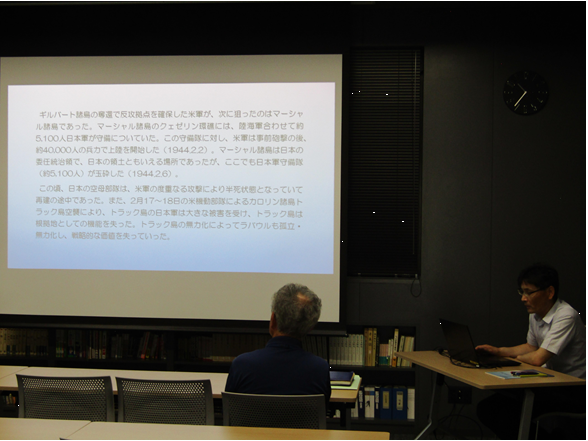 図書講座室でスクリーンを見ながら、説明する職員と話を聞く参加者