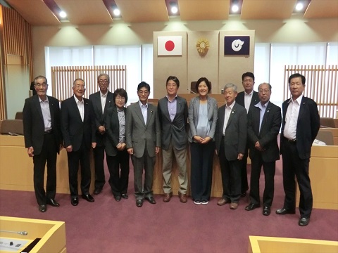 オフホワイトやベージュ色を基調とした榛東村議会室内で、11名の議員の方々が横一列に並んでいる写真