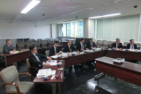 台形に設置された長机の席に議員の方々が座り前方を見ている、視察研修の様子の写真