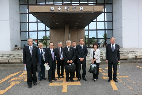 縦長の庇の先に益子町庁舎と書かれた建物の前で、9名の議員の方々が横一列に並んでいる写真