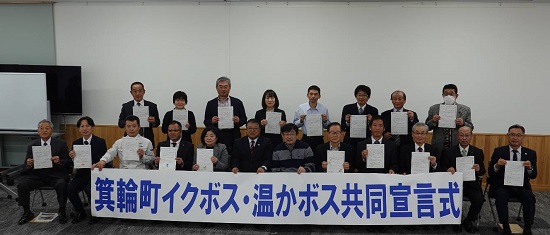 「箕輪町イクボス・温かボス共同宣言式」と書かれた横断幕を前列の方が持ち、2列になって並んでいる参加者達がそれぞれ宣言書のような紙を持って記念撮影をしている写真