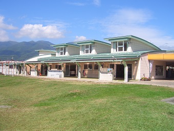 緑色の屋根をした園舎の前に緑色の芝生が広がっている松島保育園の外観写真