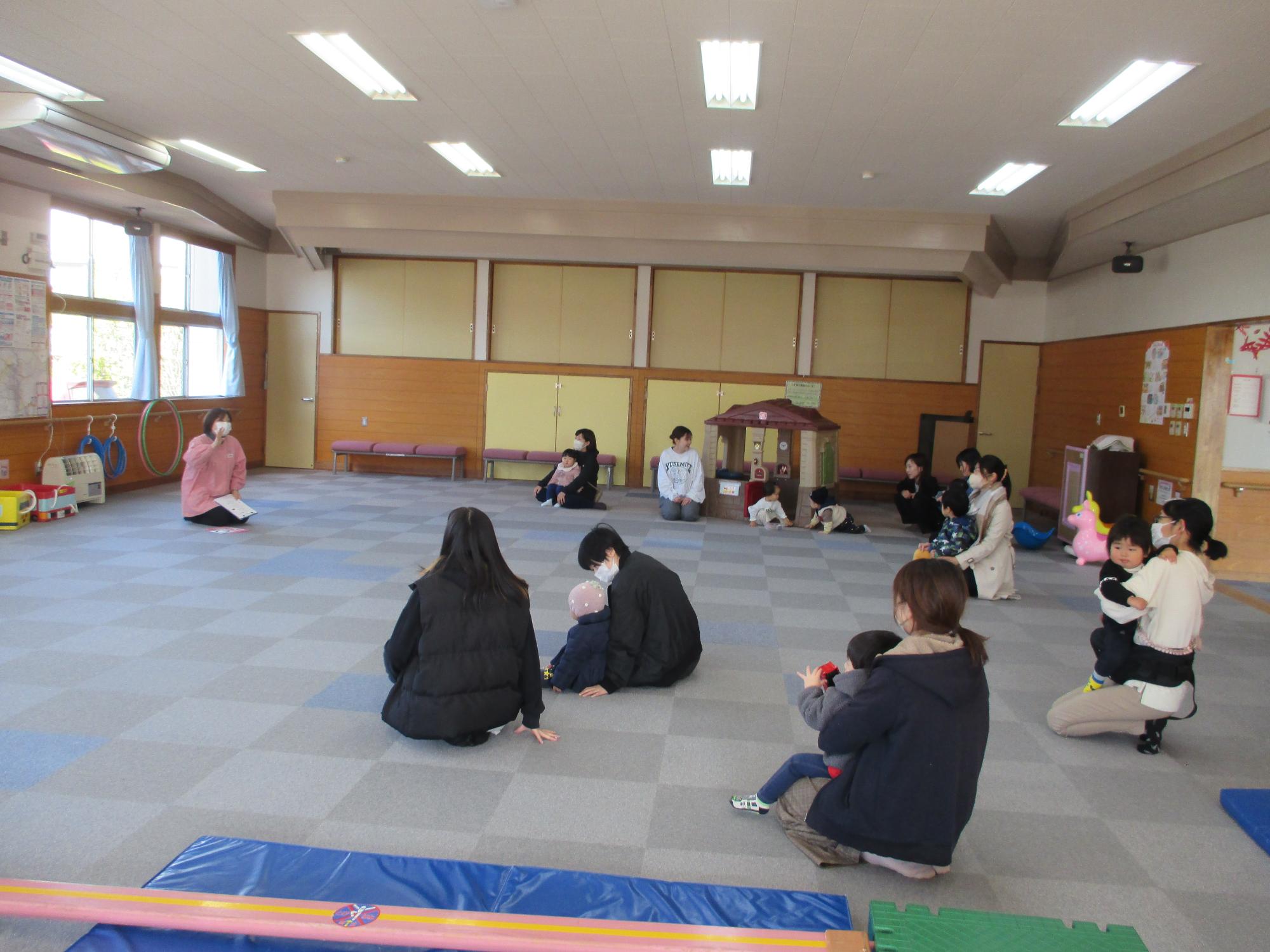 支援センターの広間に親子で座り話を聞いている