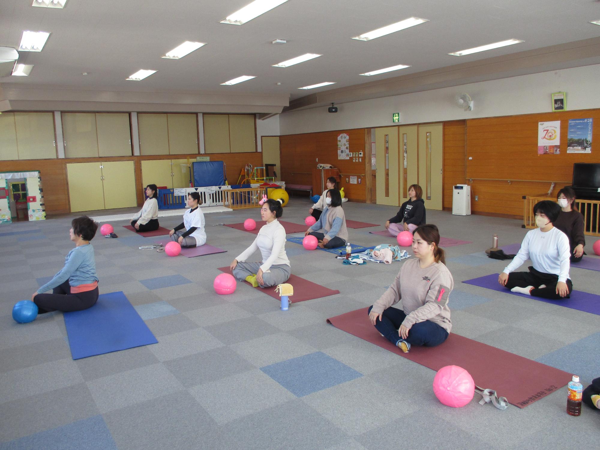 背筋を伸ばしたあぐらの姿勢で両手を膝に置いている