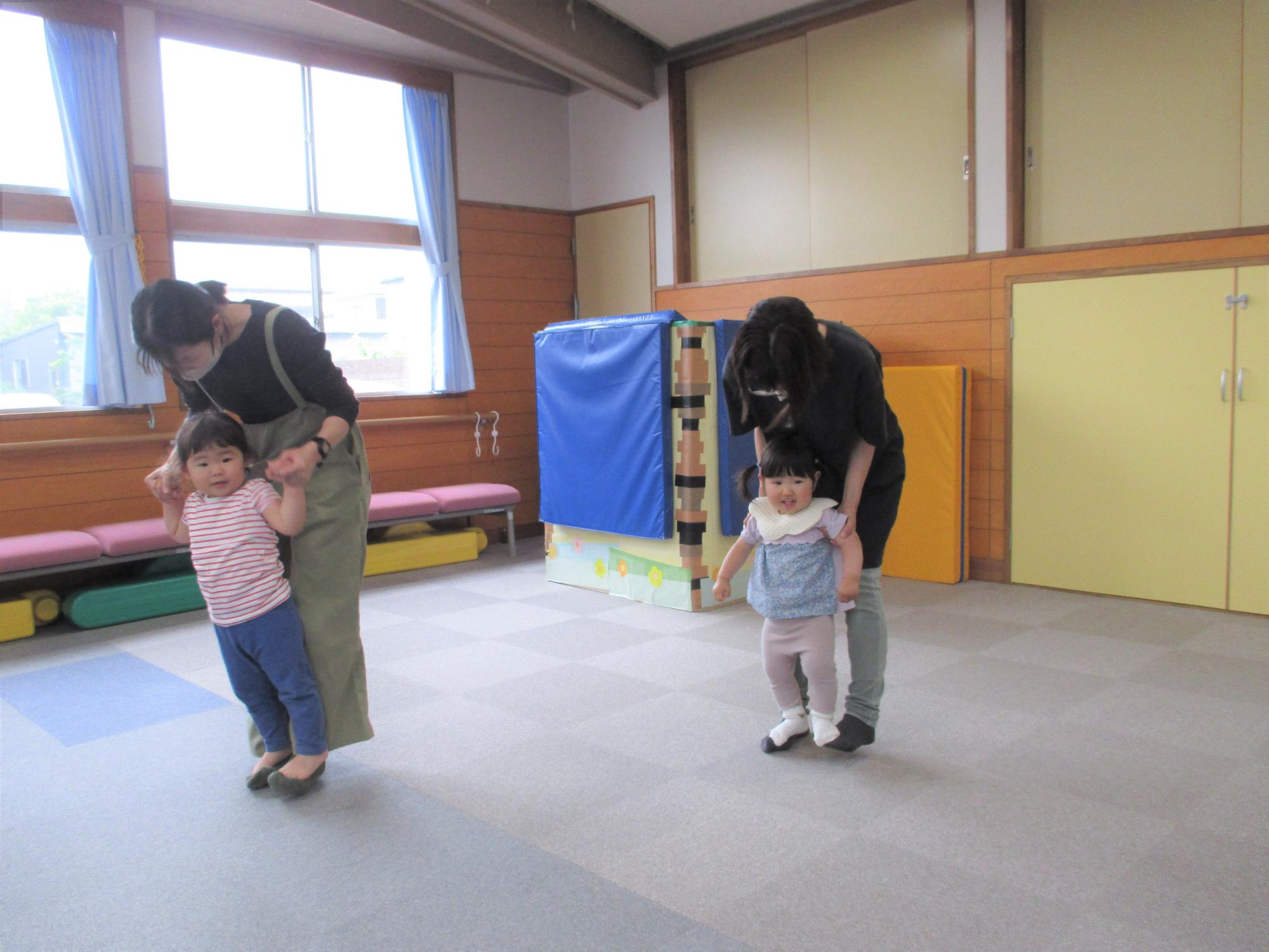 母子2組、母の足の甲に子どもの足を載せている