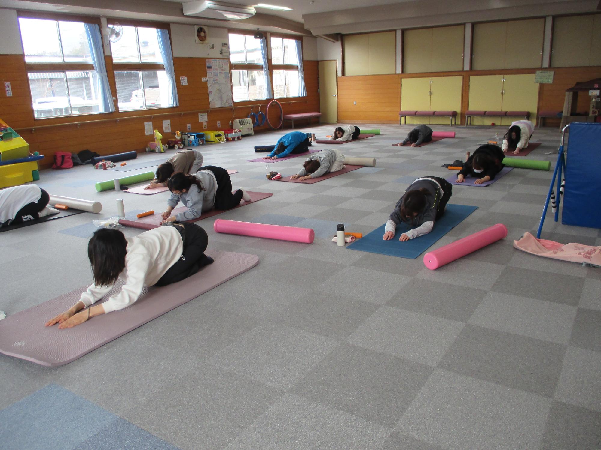 正座姿勢で両手を揃えて腕を伸ばしヨガポーズをしている