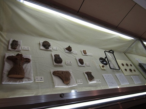 横長のショーケース内に様々な形をした土偶やミニチュア土器が展示されている写真