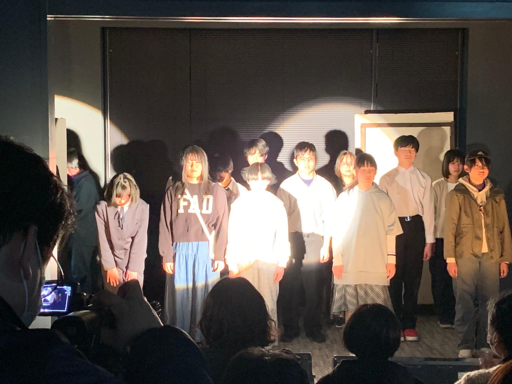 演劇部員の紹介。演劇部員が横3列に並び正面を向いて立っている