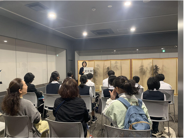 箕輪中学生の前で屏風の説明をする東京国立博物館職員の中村さん