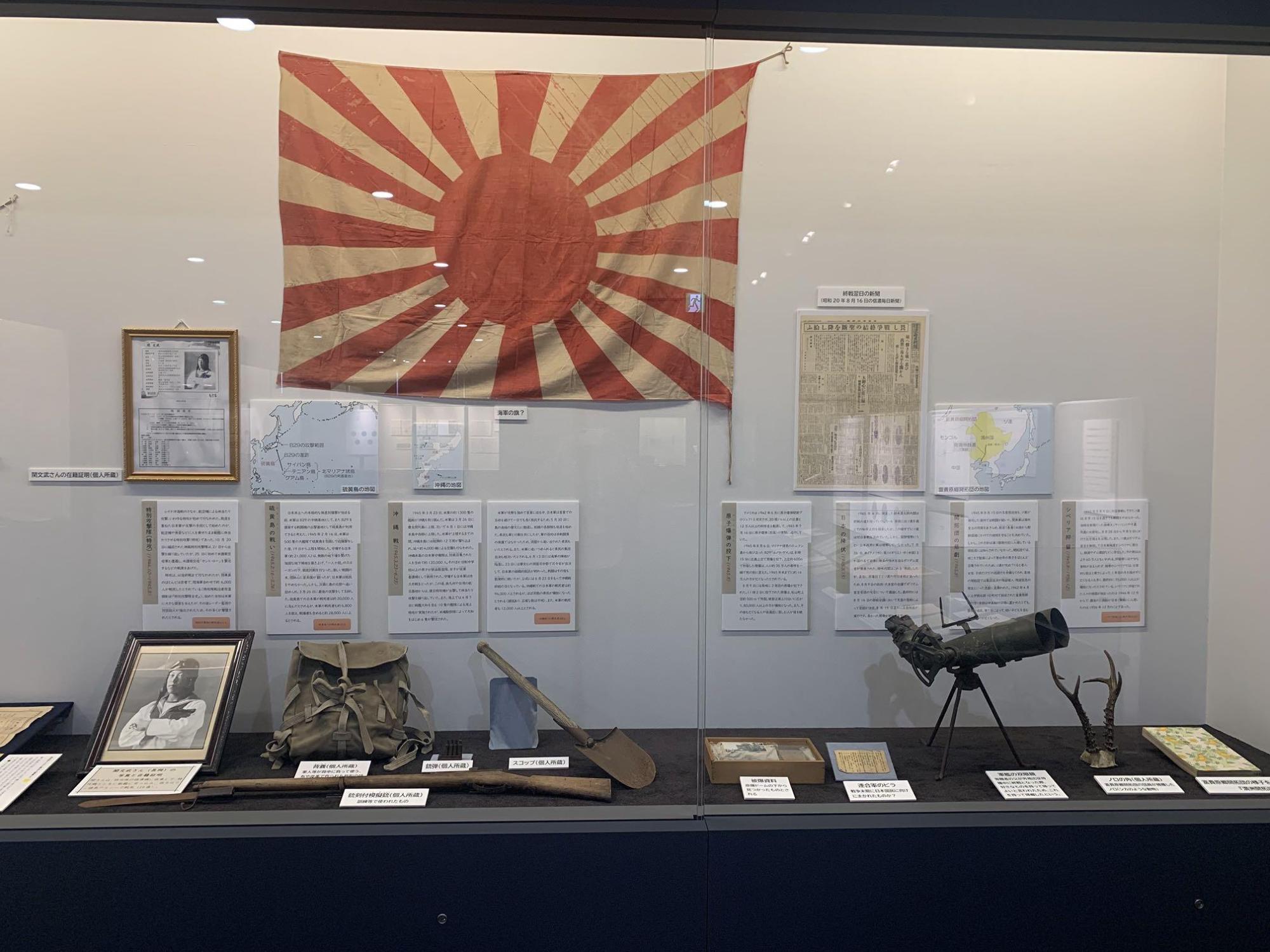 展示ケースに、亡くなった方の遺影、兵士が使っていたリュックサック、軍艦の双眼鏡などが展示されている