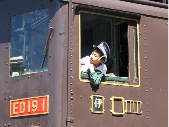 ED19の運転席から車掌の帽子をかぶって窓から顔を出す少年