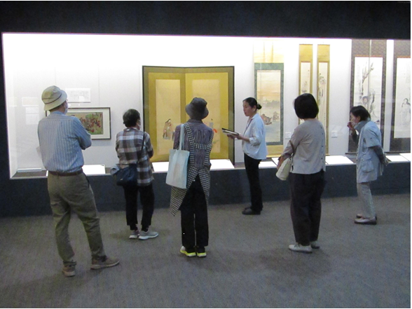 美術展示室で説明を聞きながら話を聞く参加者の皆さん