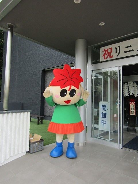 入り口前に立つ、紅葉の形をした髪型のマスコットキャラクターもみじちゃんの写真