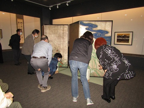 書や絵画が展示されている展示室の中央に夏秋草図が展示され、6名の方々がじっくり鑑賞している様子の写真