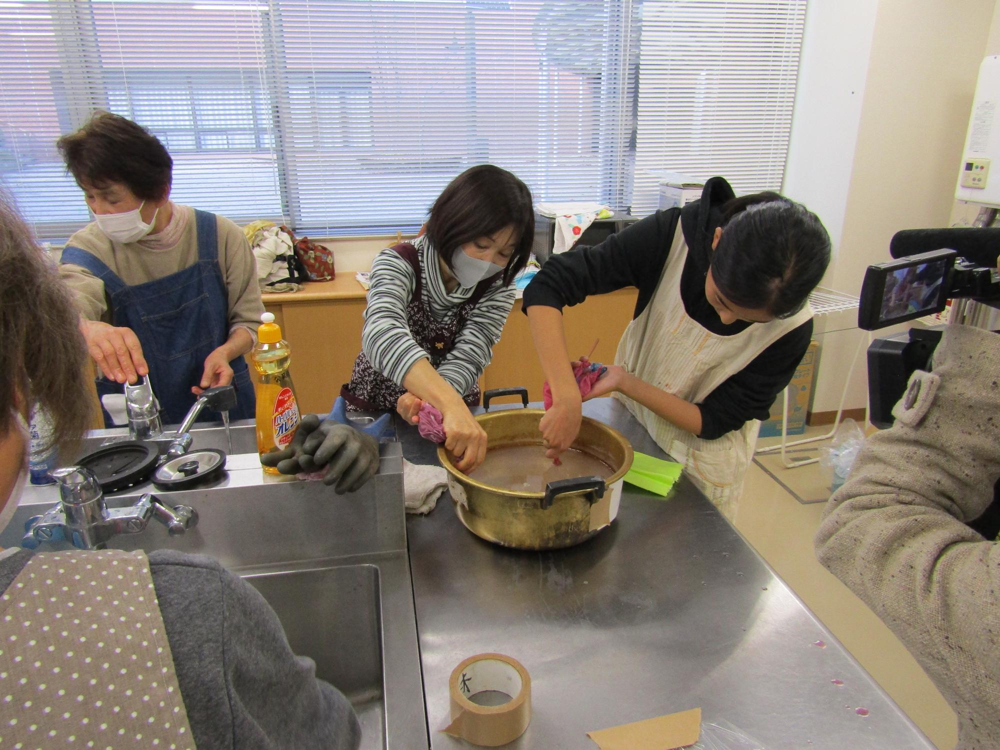 染まったハンカチの一部を石灰水につける2名の受講生