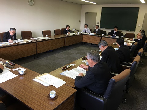 口の字型に長机が並べられた部屋で10名ほどの関係者が会議をしている様子の写真