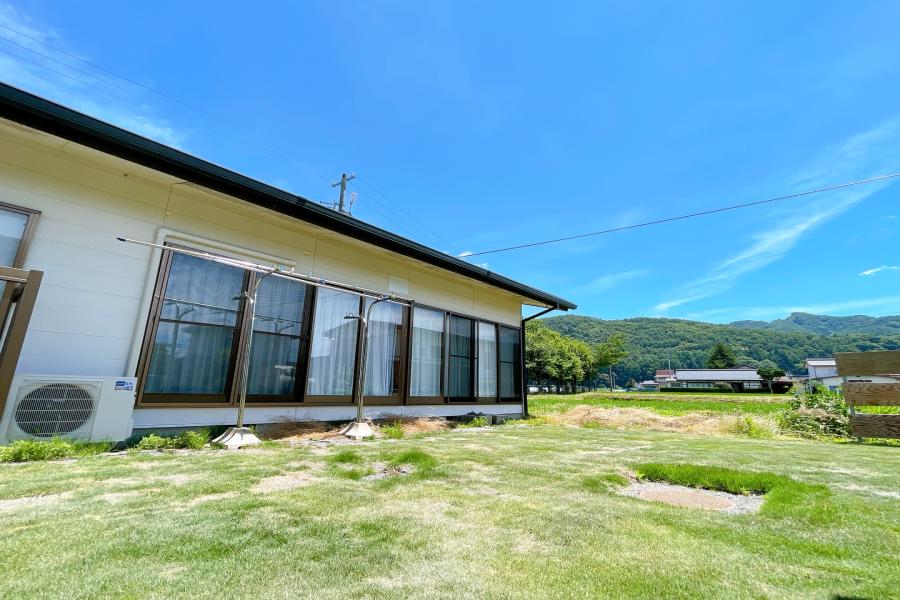 広々とした芝生の庭がある平屋の戸建て住宅の写真