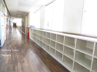 窓から陽の光が差し込む、学校の廊下を斜めに撮った写真
