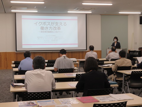 参加者達が席に座り、正面に「イクボスが支える働き方改革」と映し出されたスクリーンを見ている写真